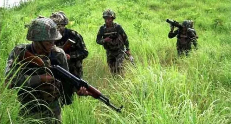 Indian Army personnel patrolling a green field during peacekeeping duty in Manipur