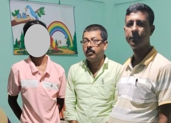 Rescued child from Hailakandi standing safely with police officers after being found at Lokmanya Tilak Terminal in Mumbai.