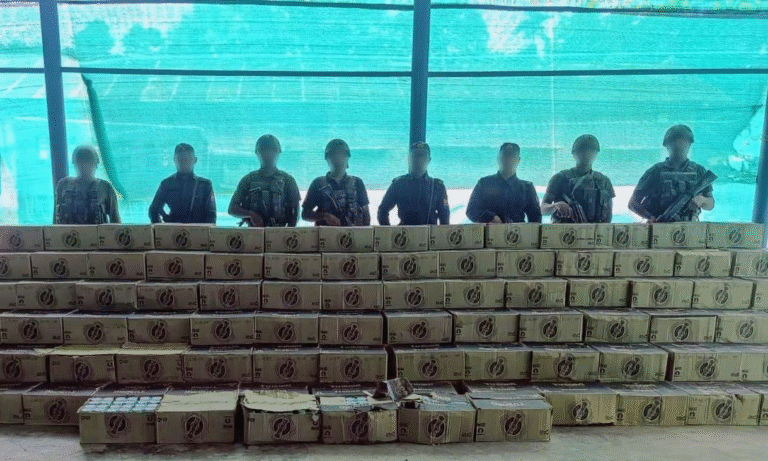 Security personnel display seized contraband boxes of country-made liquor stacked in rows